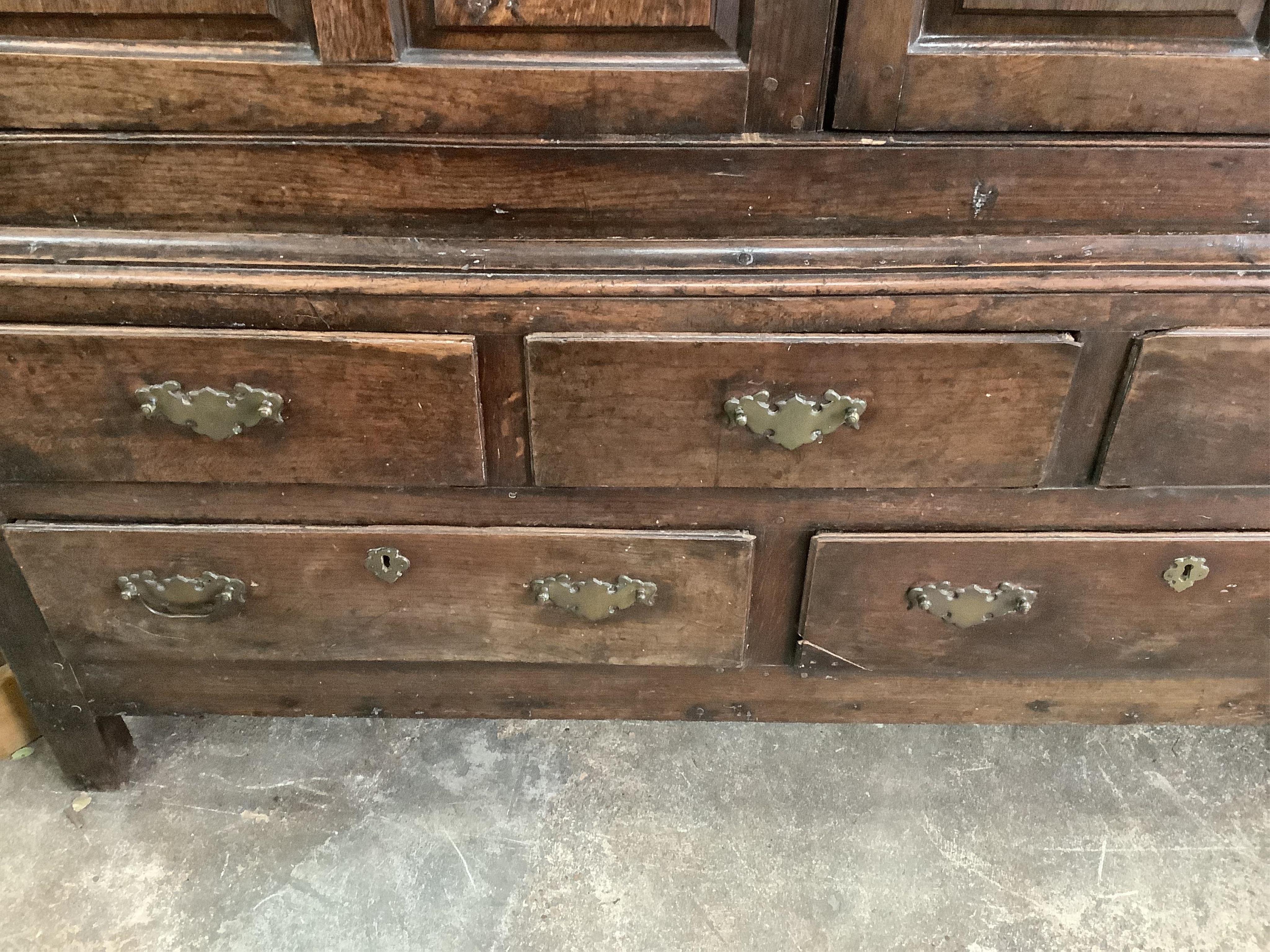 An 18th century panelled oak press cupboard, width 150cm, depth 65cm, height 183cm. Condition - poor to fair